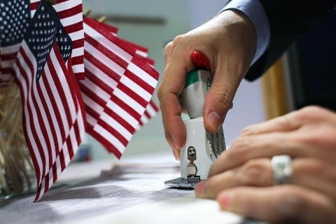 Banderas de USA en un recipiente y persona colocando un sello en una forma